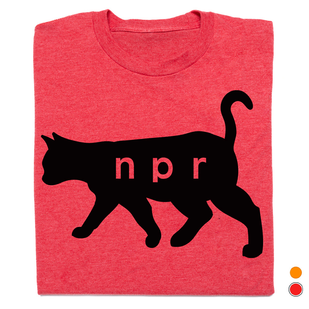 A folded heather red t-shirt featuring a black cat silhouette with the letters 'npr' printed in red across its body, shown on a white background with two small color indicator dots in the bottom right corner.