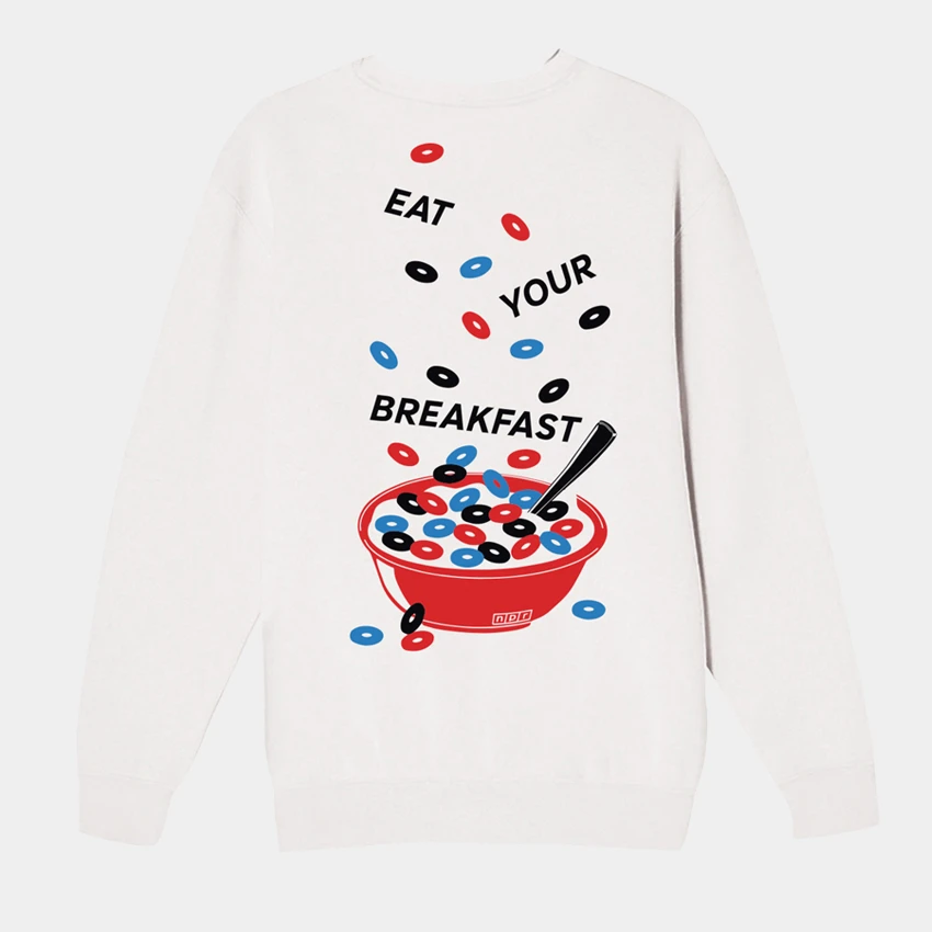 Image of the back of a white crewneck sweatshirt with an illustration of a cup of cereal and the script "eat your breakfast".