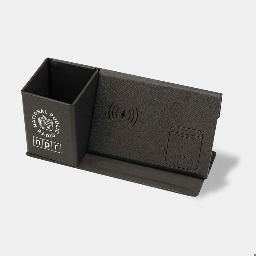 A black desk organizer with a wireless charging pad, a pen holder, and a card slot.