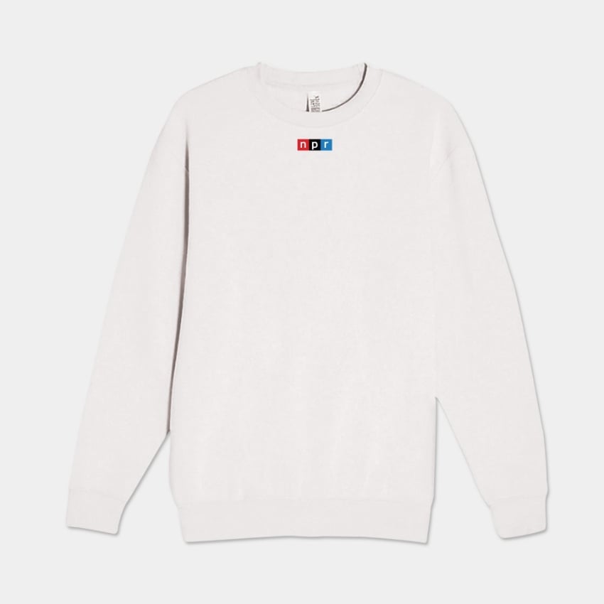 Image of the front f a white crewneck sweatshirt with a small NPR logo on it